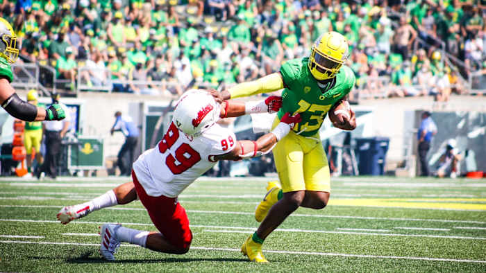 Oregon quarterback Anthony Brown stiff-arms Fresno State defensive end David Perales.